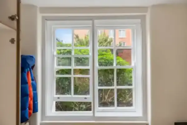 A close-up of a horizontal sliding secondary glazing unit, showing how the slim frames match the original window grid for a discreet look.
