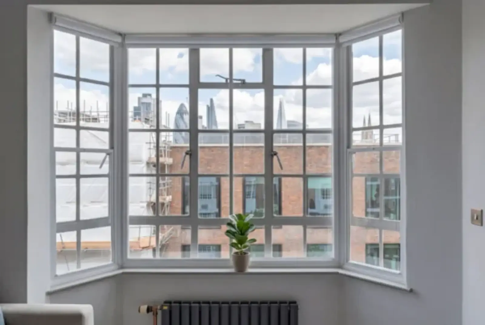 White-framed bay window overlooking London rooftops and the Shard